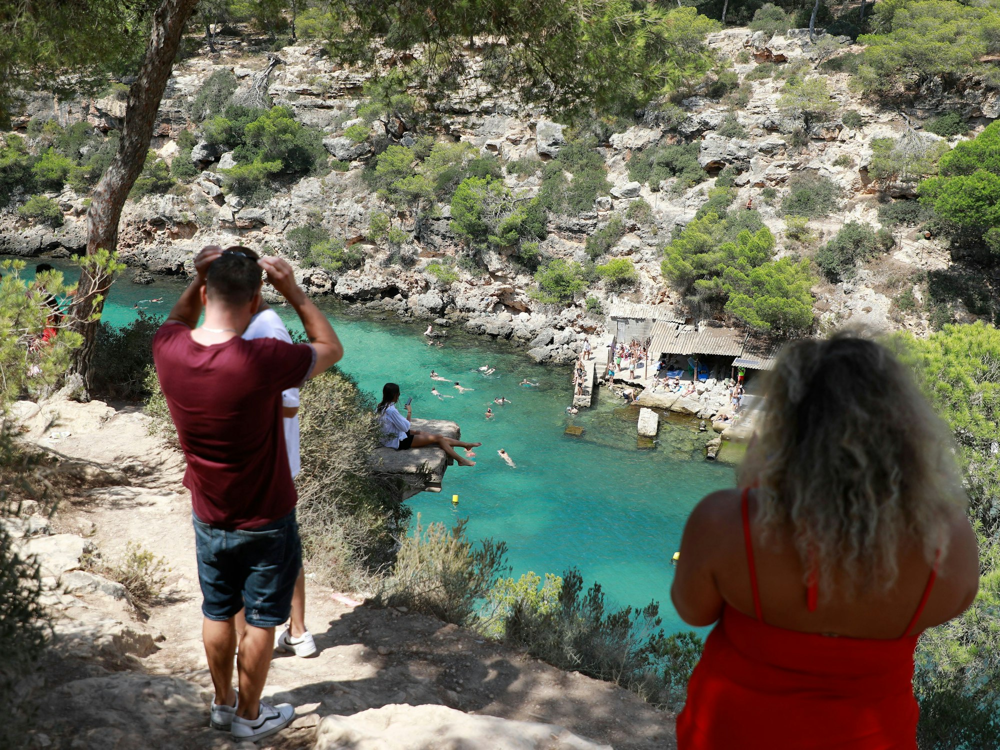 Menschen baden am Strand Cala Pi an einem heißen Sommertag.