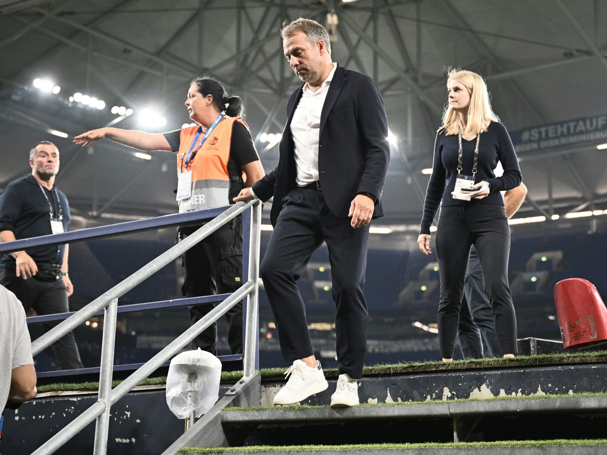 Bundestrainer Hansi Flick geht eine Treppe hinunter zur Pressekonferenz nach dem Spiel.