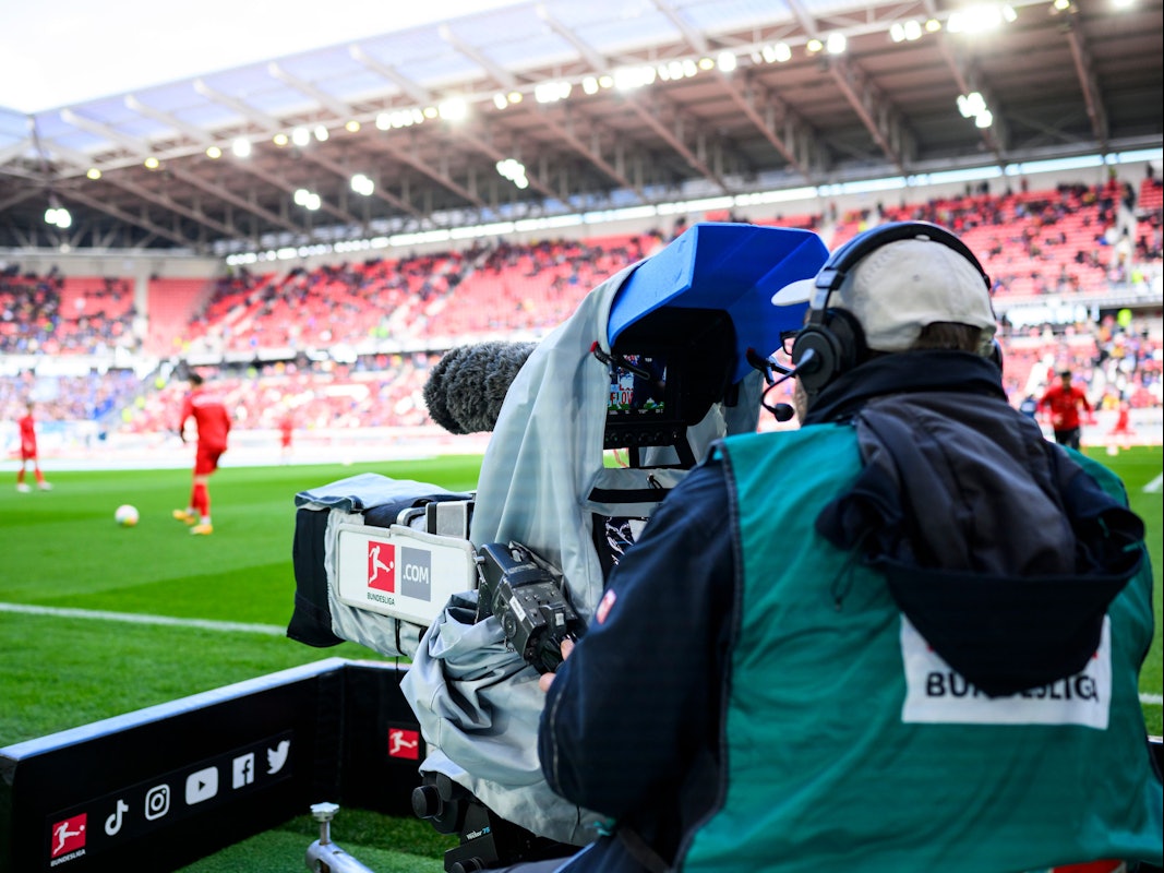 Ein Kameramann filmt bei einem Bundesliga-Spiel.