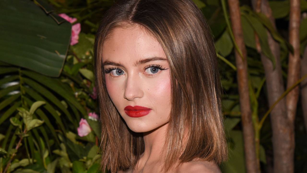 Leni Klum blickt mit kurzem braunen Bob und knalligem roten Lippenstift bei einer Filmpremiere in die Kamera.