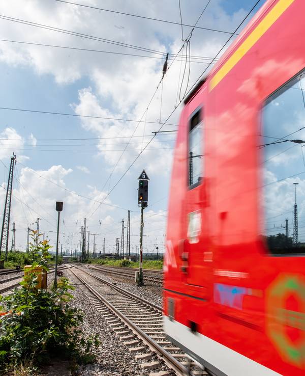 In der Scheibe einer Regionalbahn, die Richtung Dortmund fährt, spiegeln sich Hochspannungsleitungen, hier im Mai 2018.