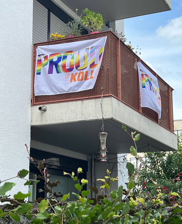 Fahnen mit der Aufschrift „Proud op Kölle“ hängen an einem Balkon in Köln-Nippes.