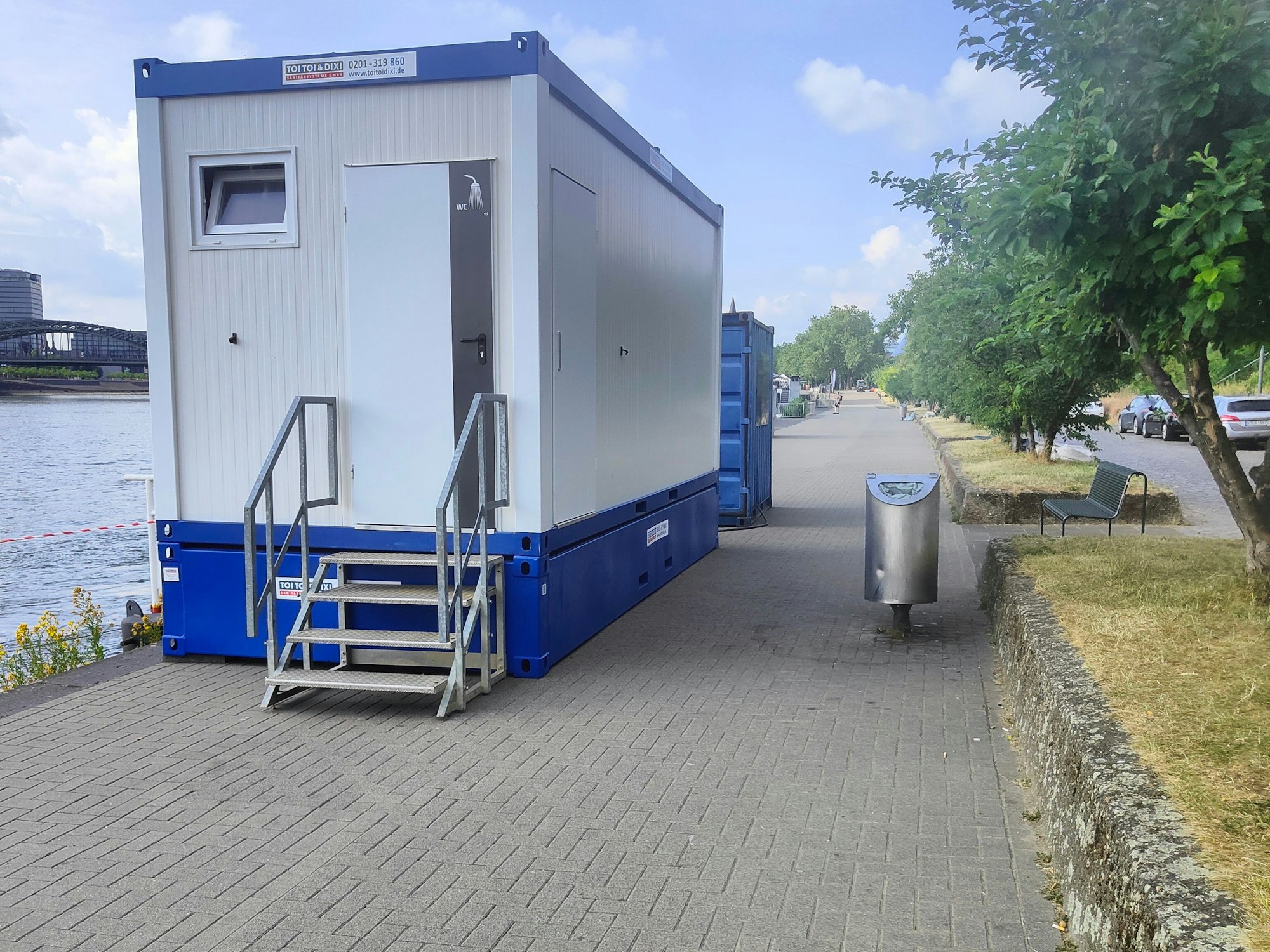 Ein Klo-Container steht am Rhein.