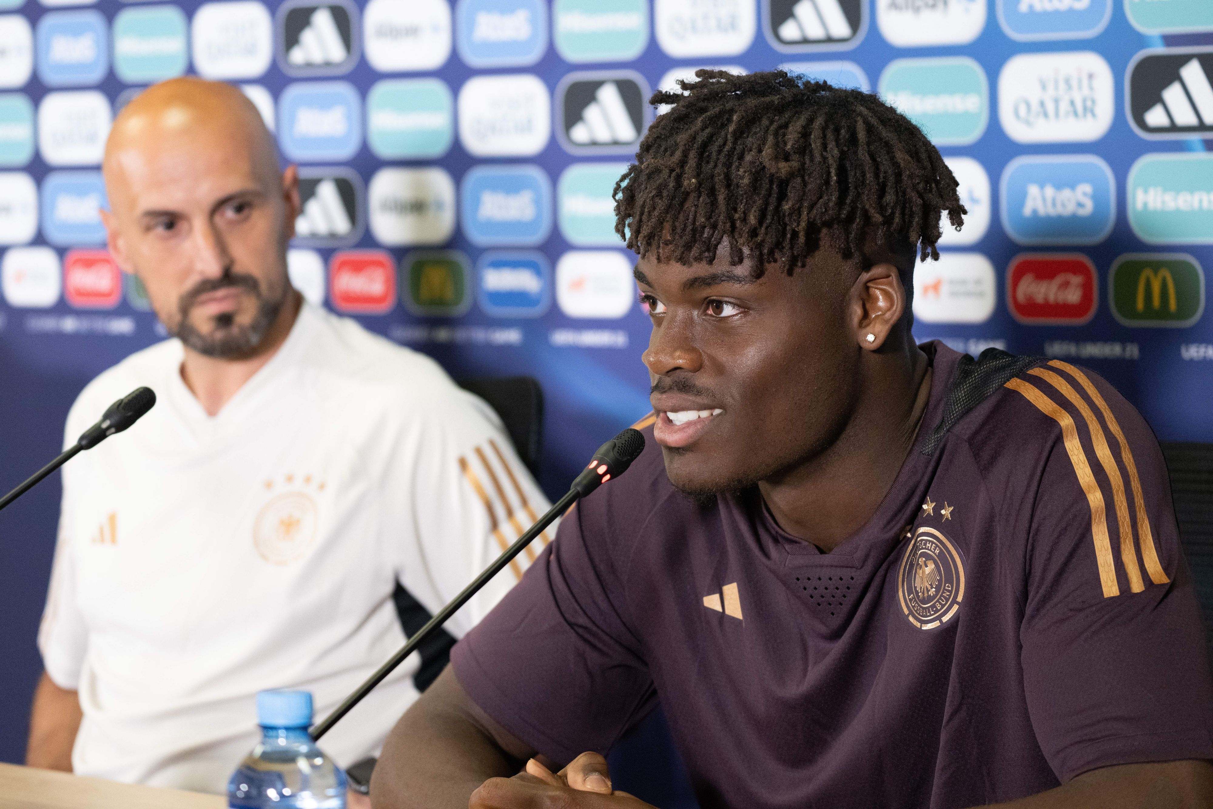 Antonio Di Salvo (l), Trainer, und Yann Aurel Bisseck, Spieler und Kapitän der deutschen U21-Nationalmannschaft, nehmen vor Beginn des Trainings der deutschen U21-Nationalmannschaft an einer Pressekonferenz teil.