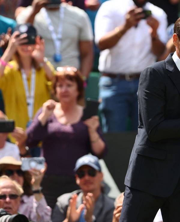 Die beiden ehemaligen Tennisstars Roger Federer (l.) und John McEnroe (r.) geben sich im Rahmen des Tennisturniers vom Wimbledon die Hand.
