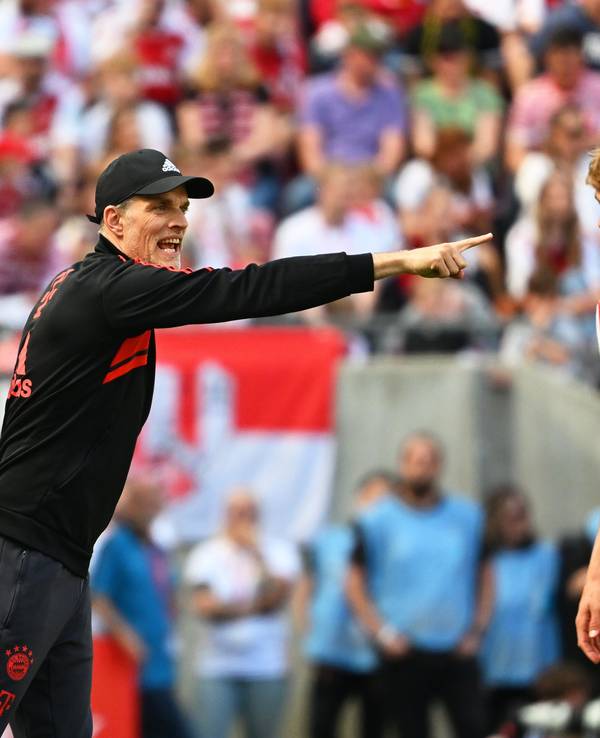 Bayerns Trainer Thomas Tuchel reagiert an der Seitenlinie, Kölns Timo Hübers schaut genau hin.