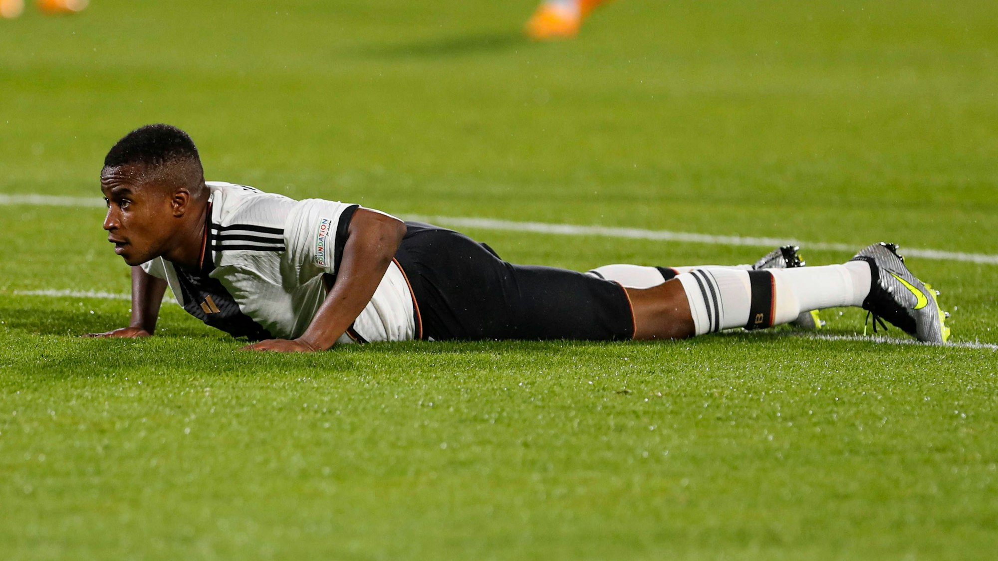 Youssoufa Moukoko liegt auf dem Rasen.