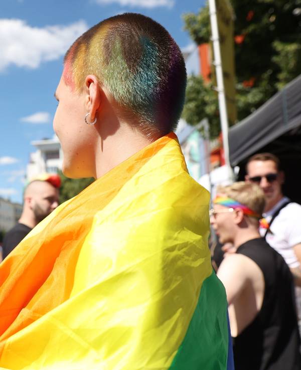 Eine junge Frau, die auf der CSD-Demo 2022 eine Regenbogenfahne trägt.