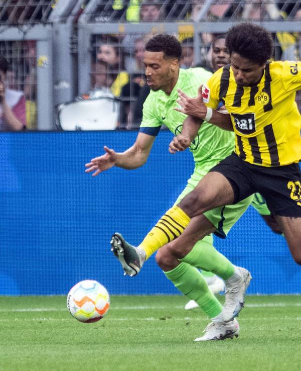 Dortmunds Karim Adeyemi (r) und Felix Nmecha von Wolfsburg im Zweikampf um den Ball.