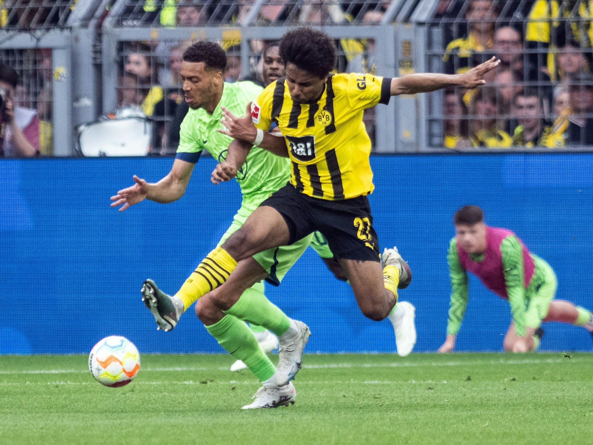 Dortmunds Karim Adeyemi (r) und Felix Nmecha von Wolfsburg im Zweikampf um den Ball.