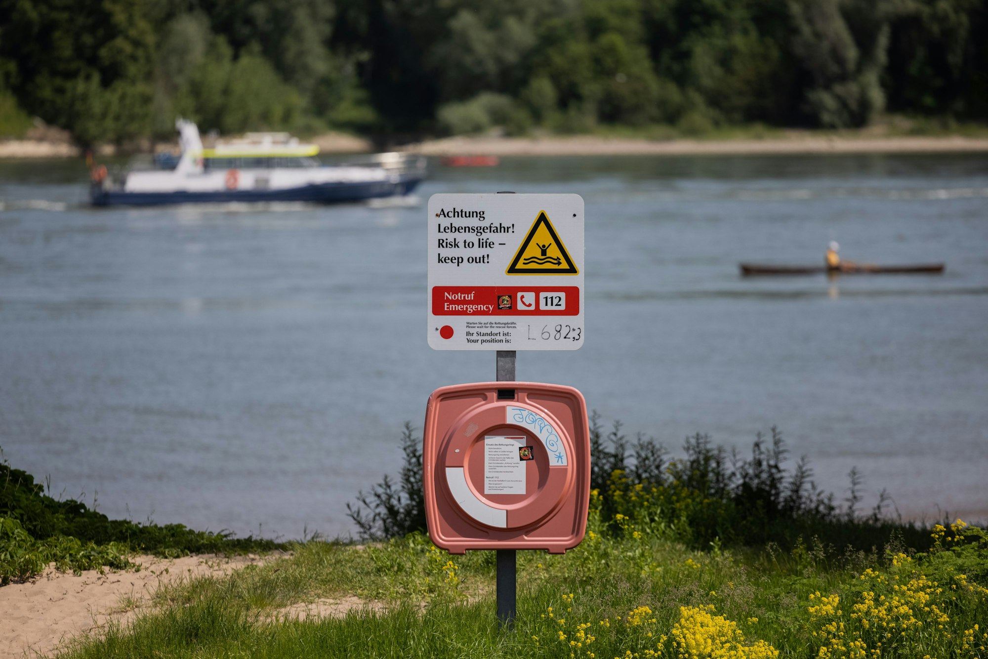 Ein Hinweisschild mit der Aufschrift ‚Achtung Lebensgefahr‘ weist am Rhein in Rodenkirchen auf die Gefahren beim Schwimmen in dem Fluss hin. In den Sommermonaten gibt es Jahr für Jahr tödliche Badeunfälle.