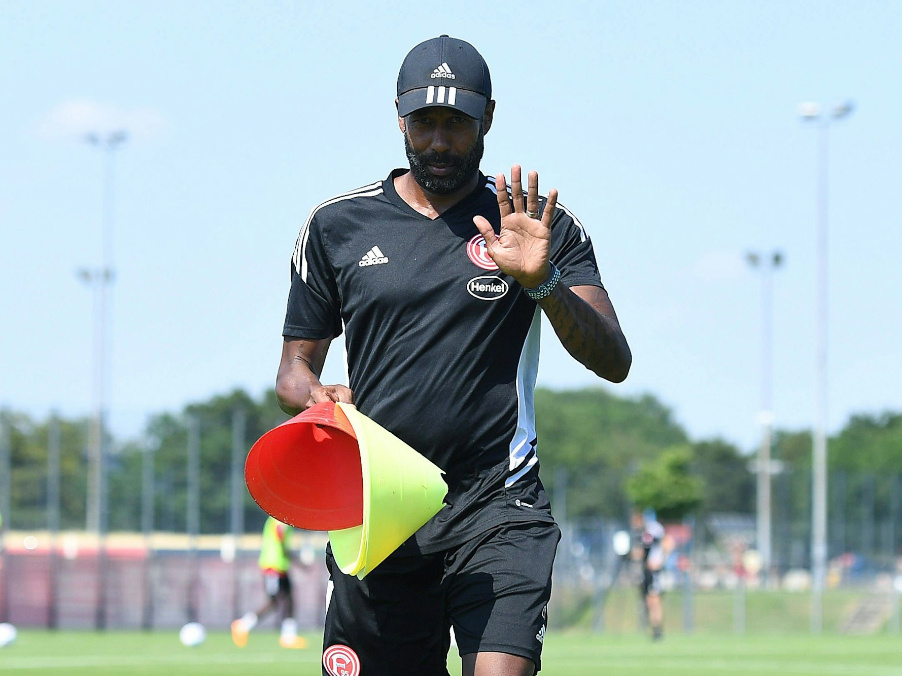 Düsseldorfs Cheftrainer Daniel Thioune winkt beim Training in die Kamera.