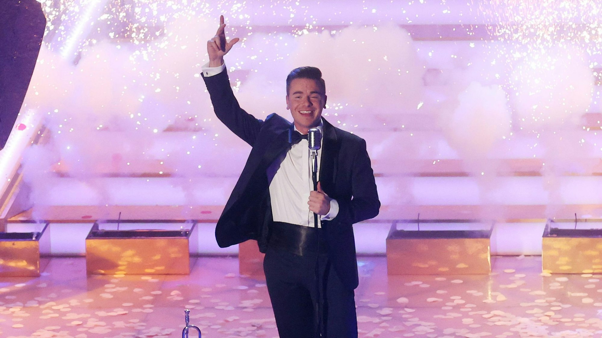 Eric Philippi singt im Smoking auf der Bühne