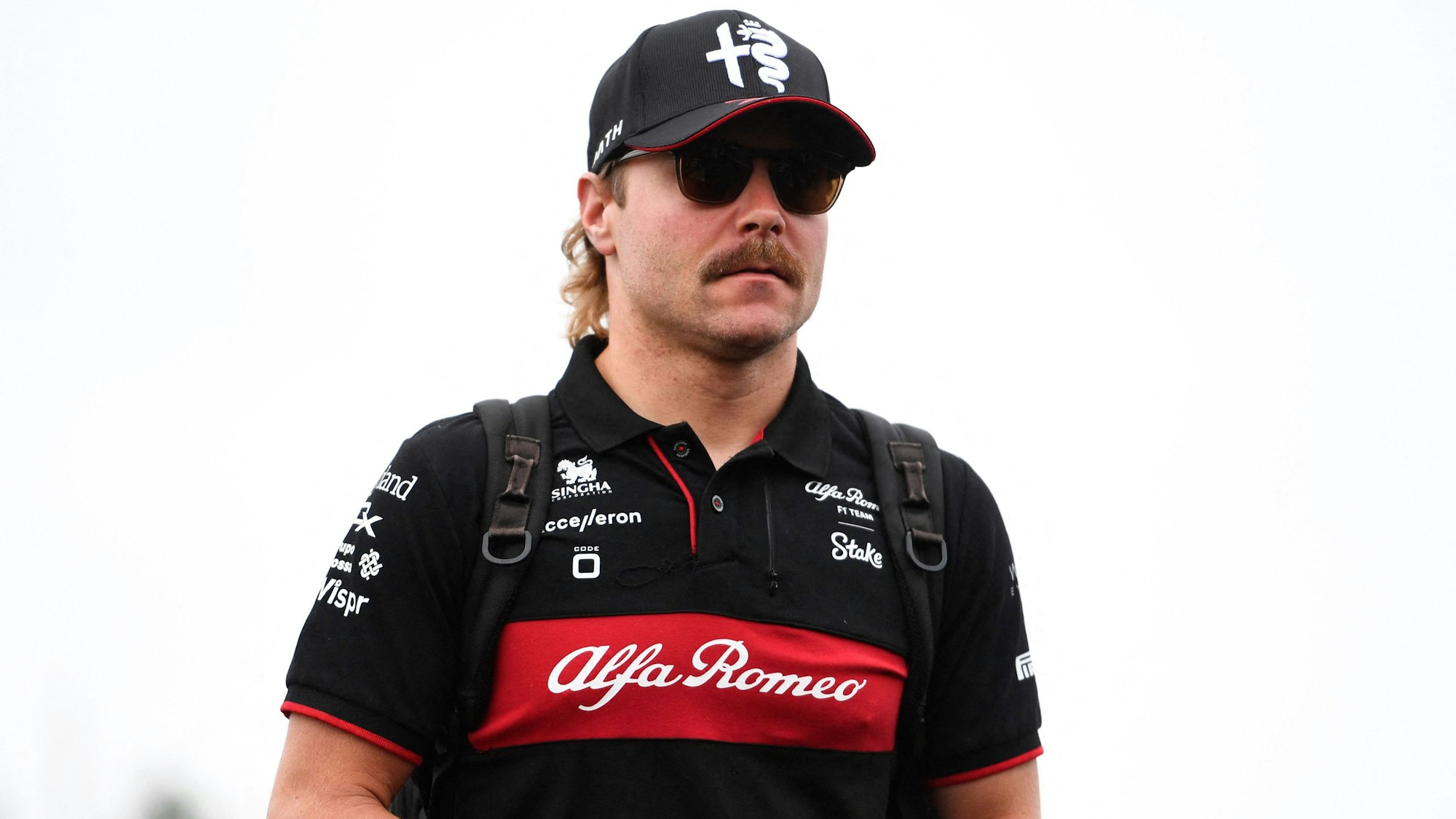 Valtteri Bottas läuft mit Sonnenbrille durch die Boxengasse.