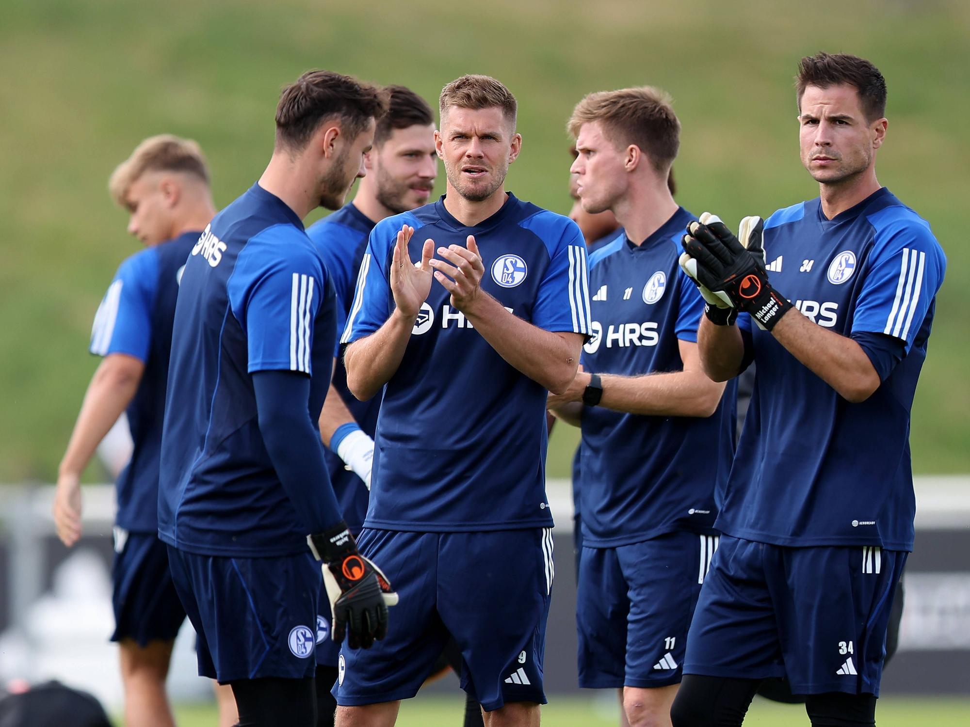 Simon Terodde und Michael Langer klatschen beim Trainingsauftakt des FC Schalke 04.