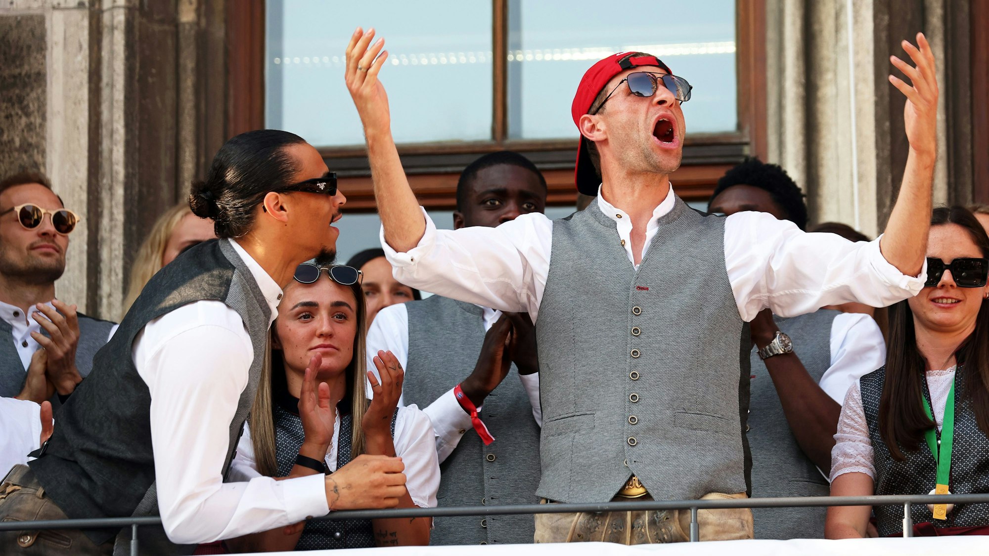 Leroy Sané und Thomas Müller feiern in Lederhosen bei der Meisterfeier des FC Bayern München am 28. Mai 2023 auf dem Rathausbalkon.