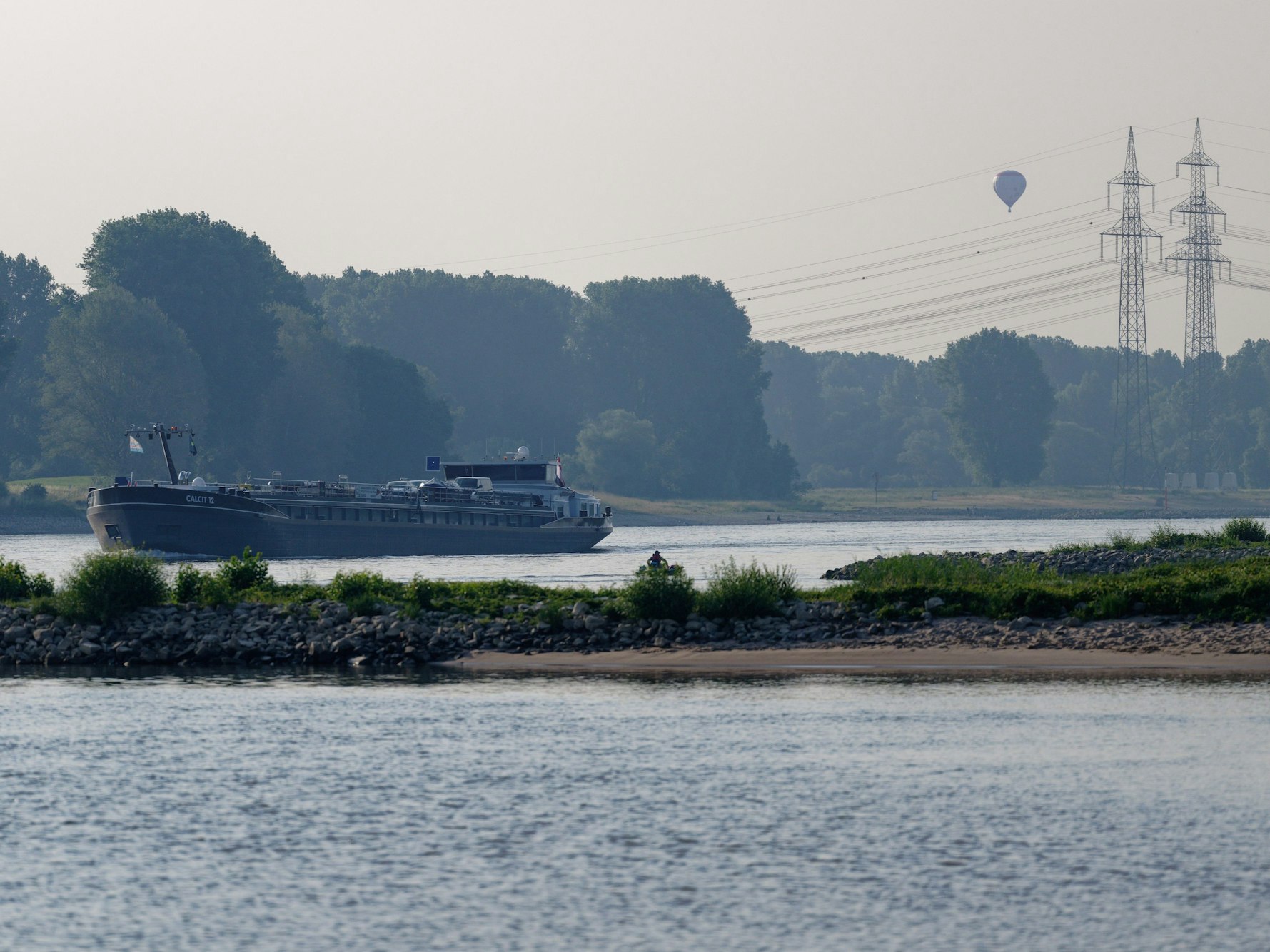 Ein Schiff fährt am Morgen auf dem Rhein bei Köln-Langel.