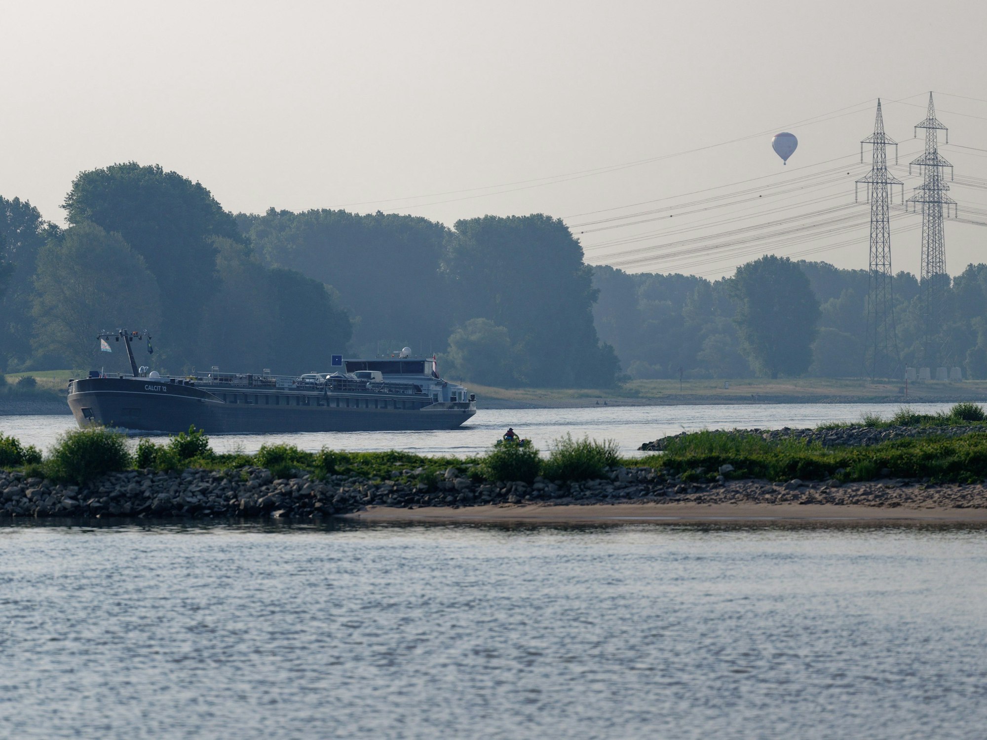 Ein Schiff fährt am Morgen auf dem Rhein bei Köln-Langel.