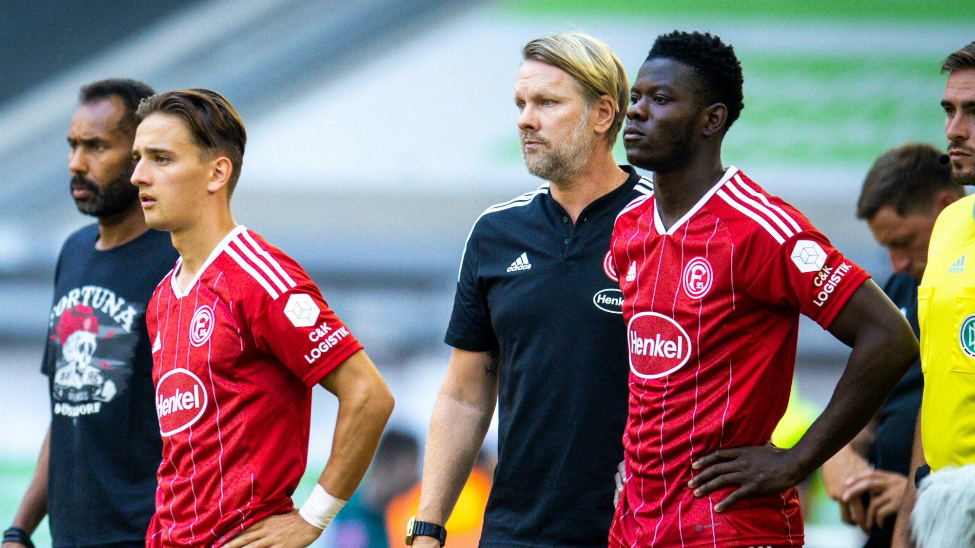 Chefcoach Daniel Thioune, Michal Karbownik, Lizenspieler-Chef Sascha Rösler und Kwadwo Baah stehen beim Spiel gegen Greuther Fürth am Spielfeldrand.