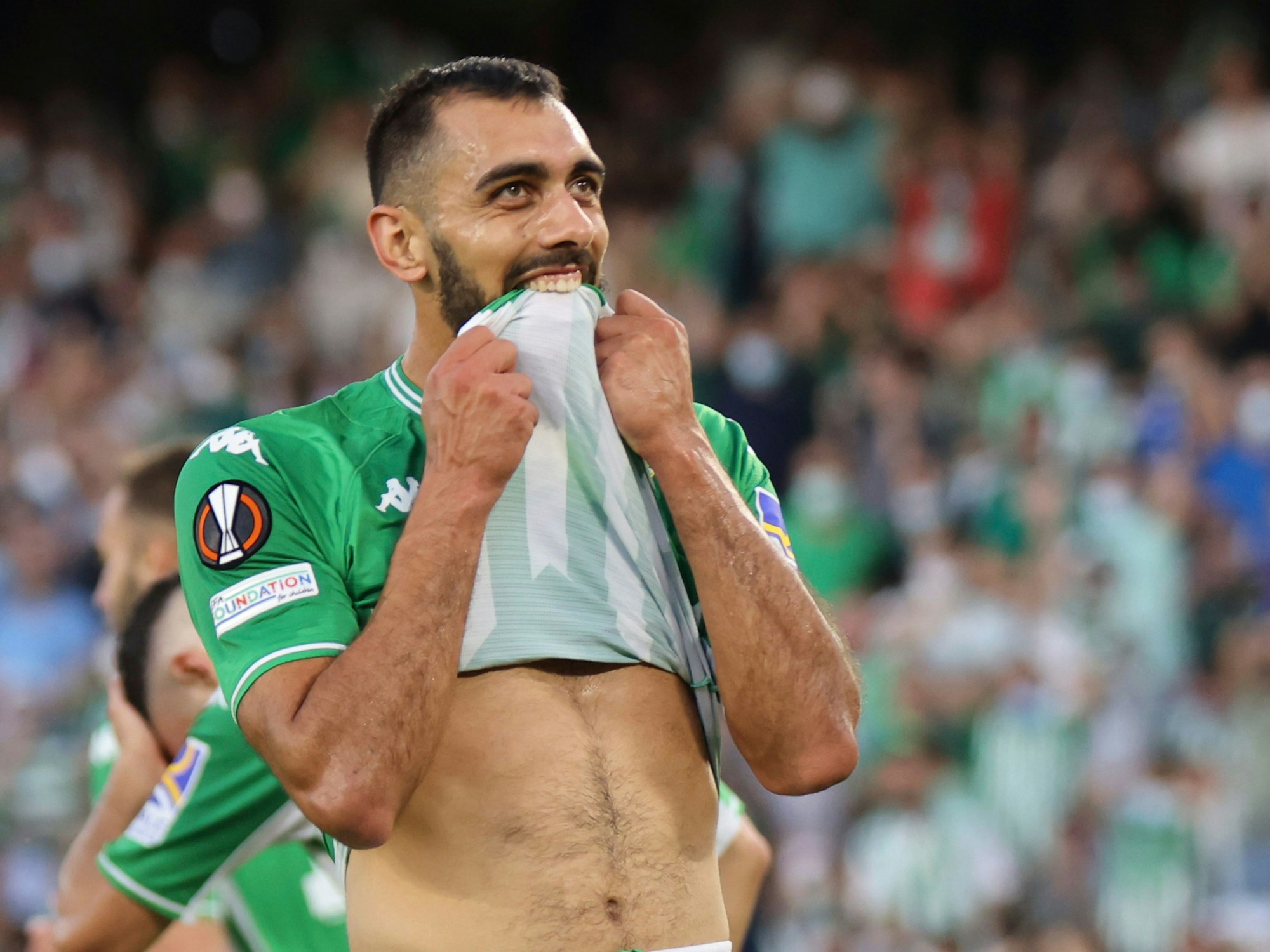 Borja Iglesias beißt in sein Trikot.