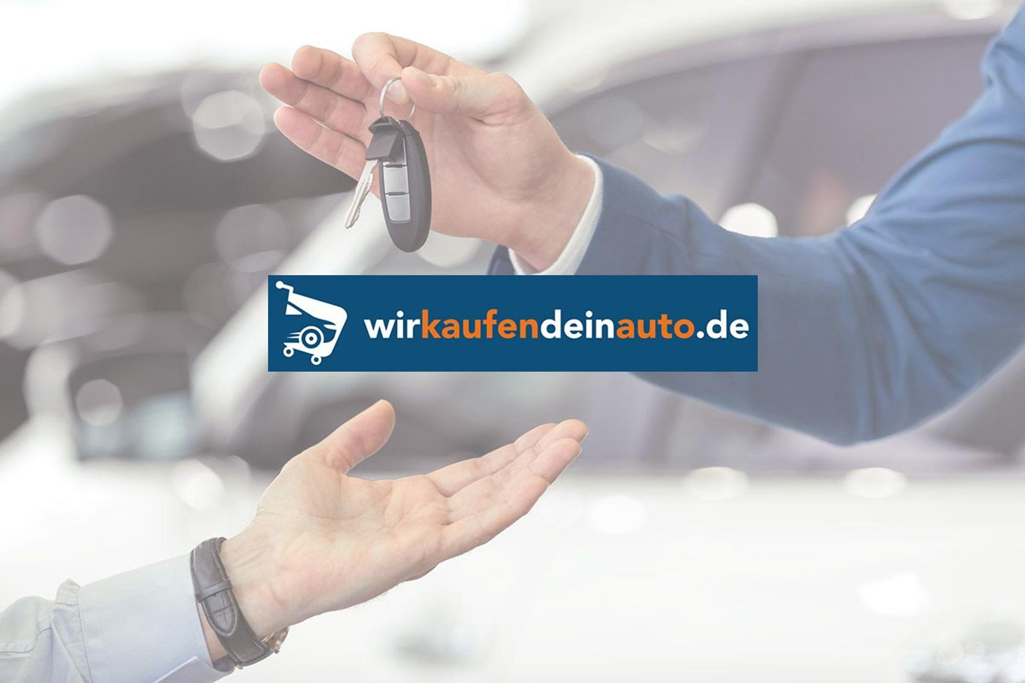 Mann gibt Autoschlüssel an anderen Mann. Bild zu Gebrauchtwagen verkaufen.