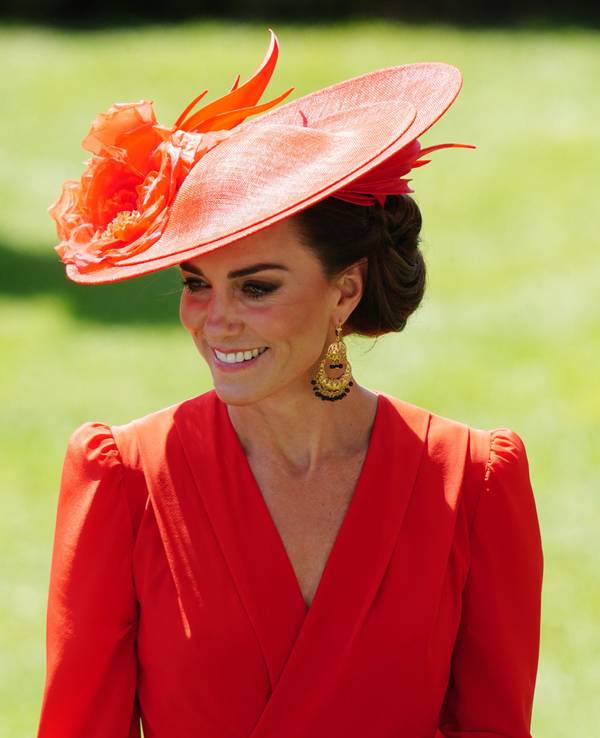 Kate, Prinzessin von Wales, trägt ein rotes Outfit inklusive Hut.