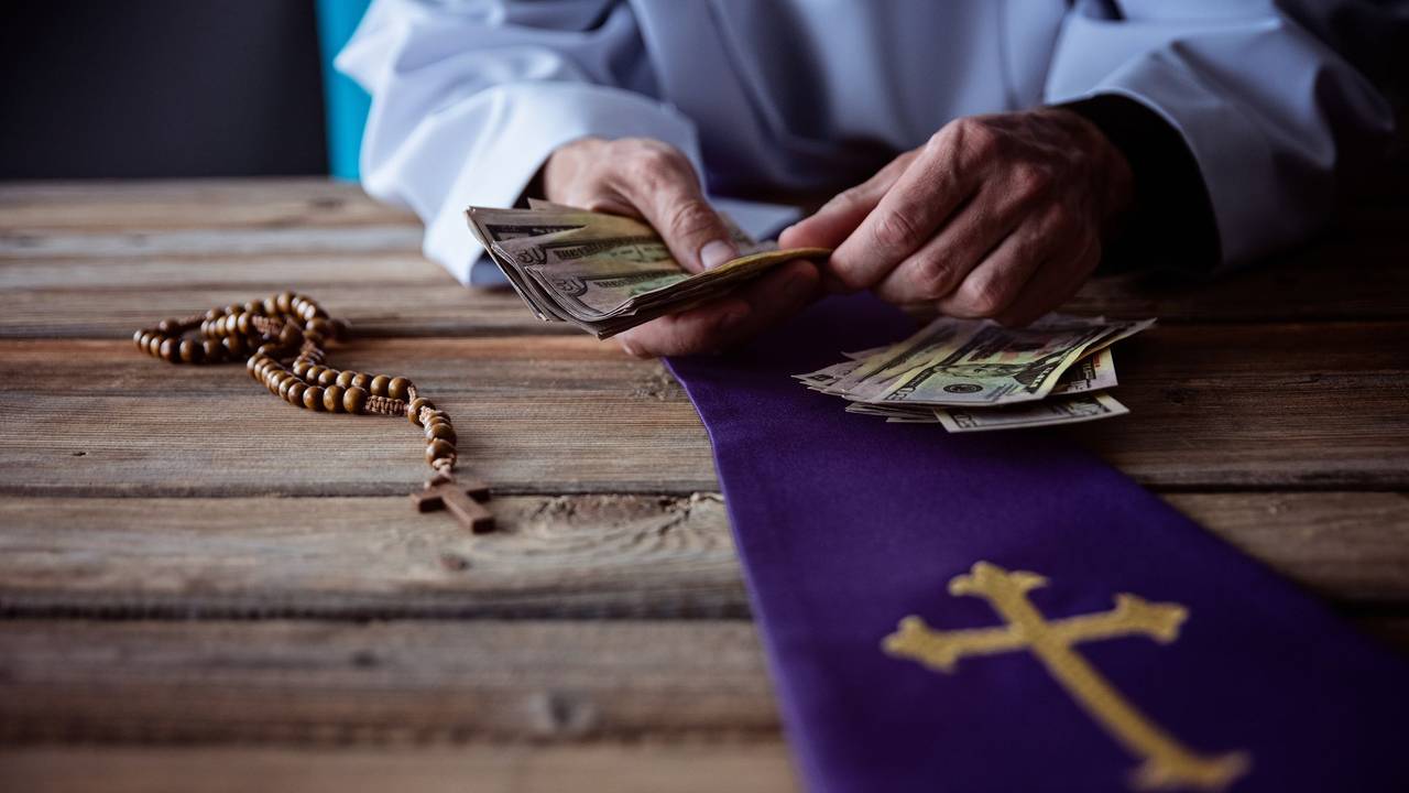 Ein Priester zählt Geld.