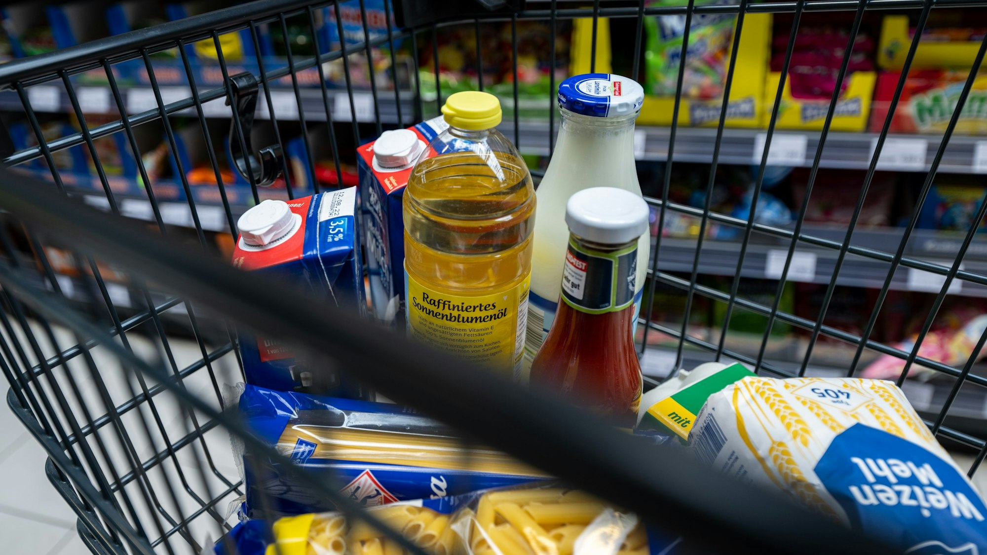 Lebensmittel liegen in einem Einkaufswagen in einem Supermarkt.