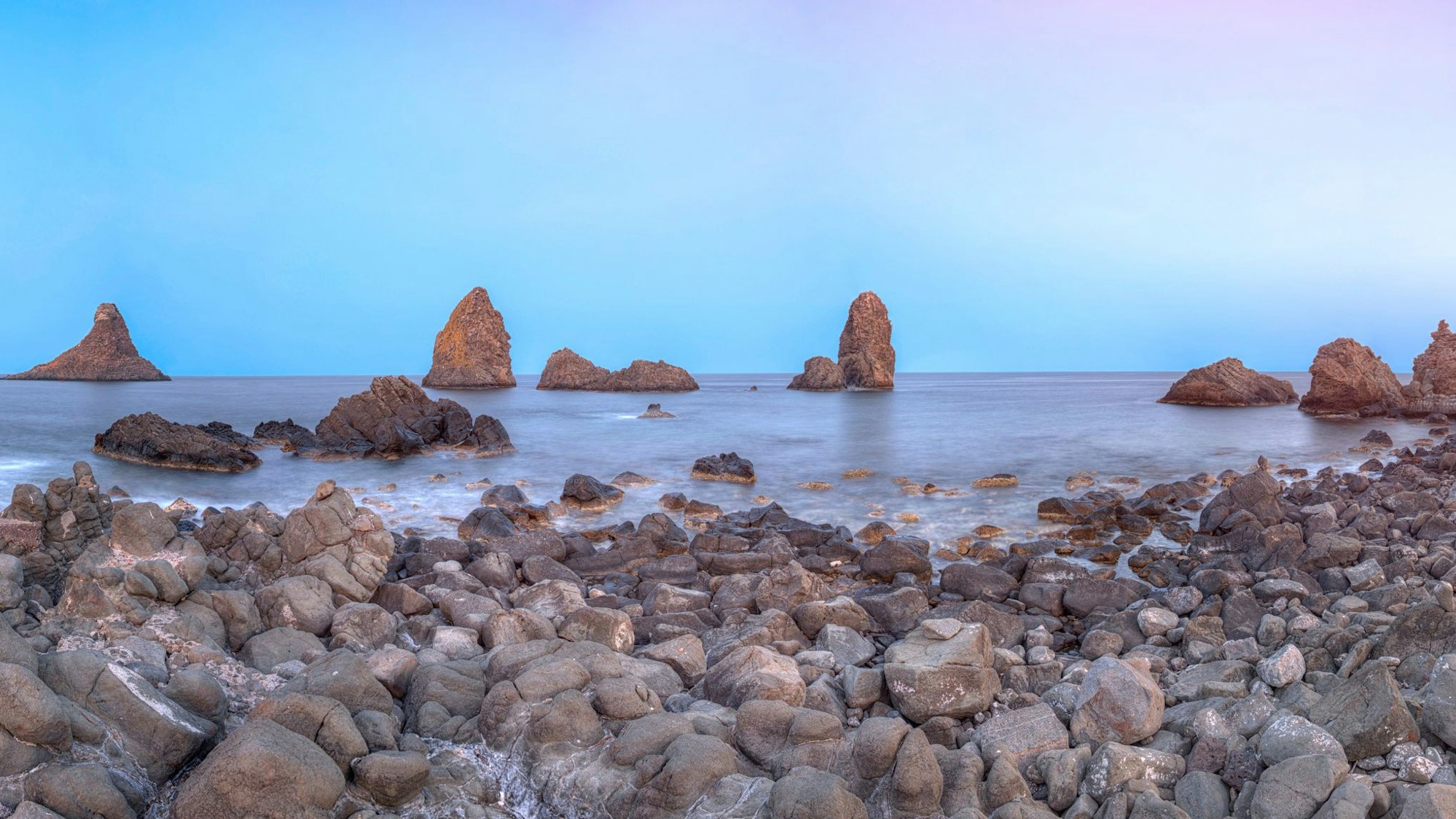 Auf dem Foto sieht man den Strand von Riviera dei Ciclopi und das Vulkangestein.