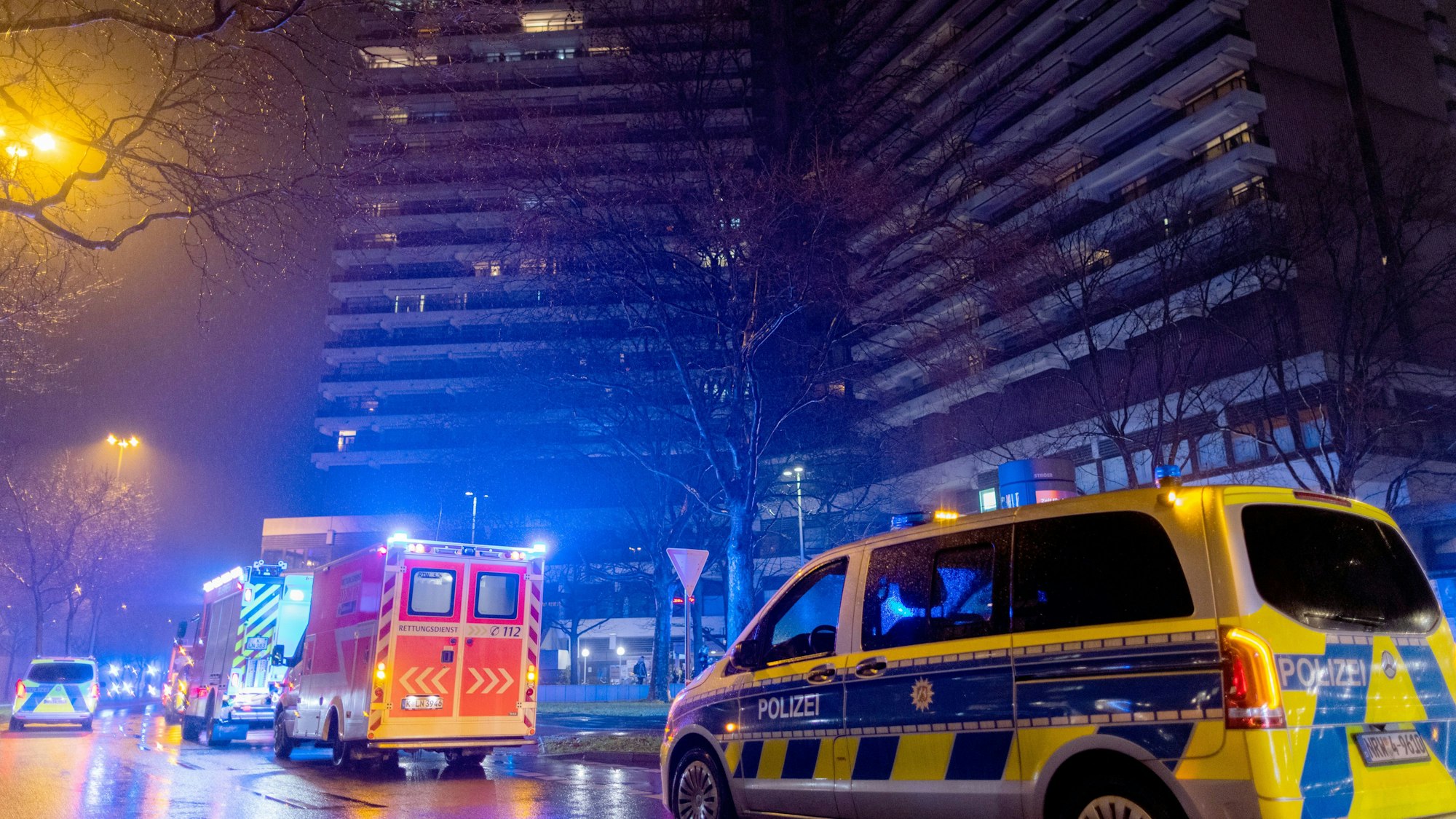 Einsatzkräfte der Feuerwehr stehen vor dem Uni-Center.