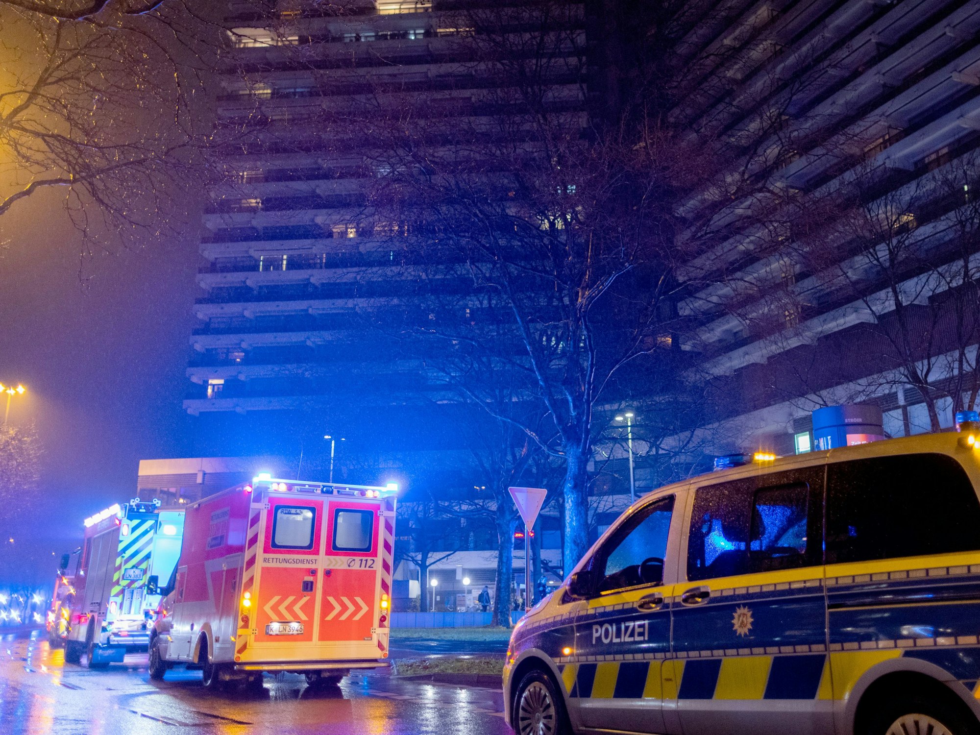 Einsatzkräfte der Feuerwehr stehen vor dem Uni-Center.