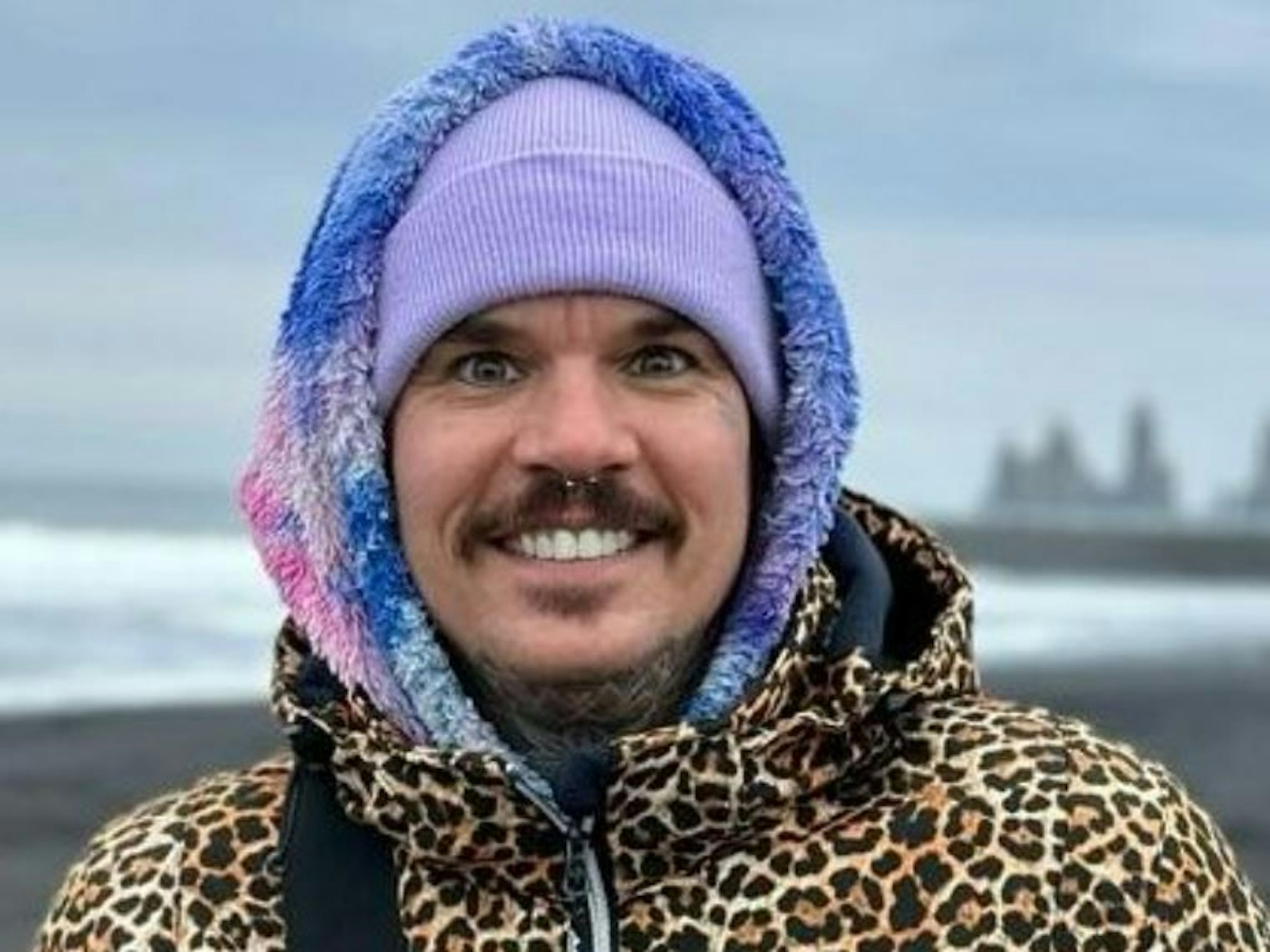 Jill Deimel, hier mit dicker Leo-Jacke und bunter Kapuze, schaut grinsend in die Kamera.