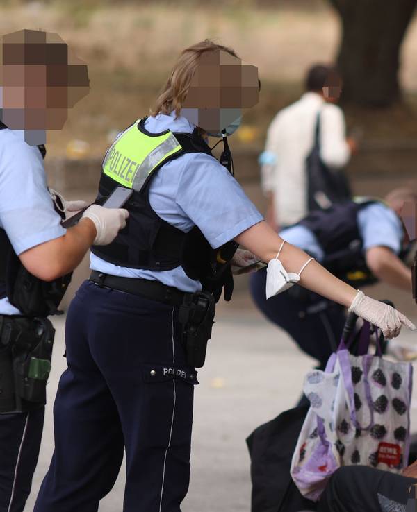 Polizisten kontrollieren Personen während einer Razzia