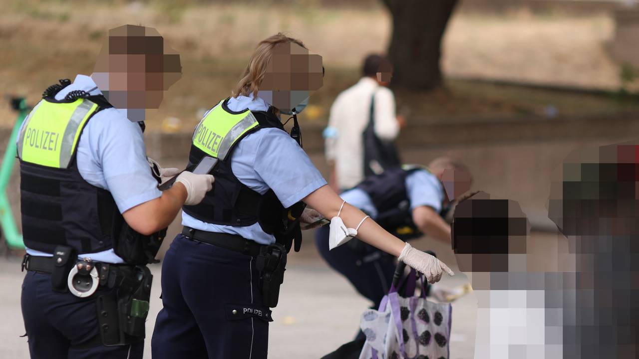 Polizisten kontrollieren Personen während einer Razzia