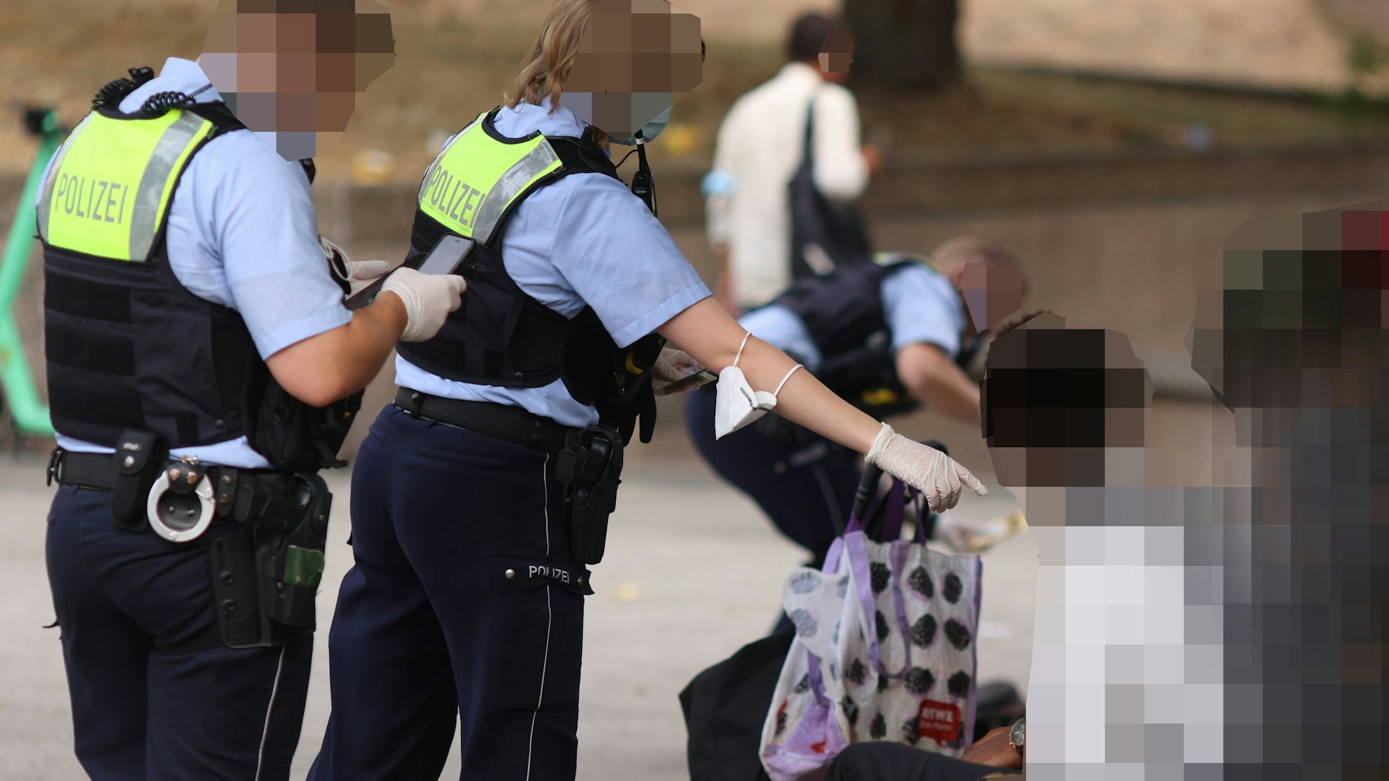 Einsatzkräfte der Polizei kontrollieren mehrere Personen am Ebertplatz.