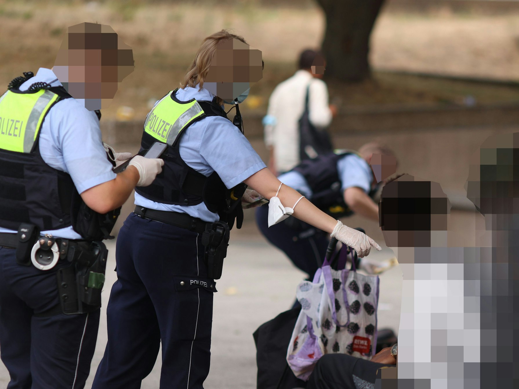 Polizisten kontrollieren Personen während einer Razzia