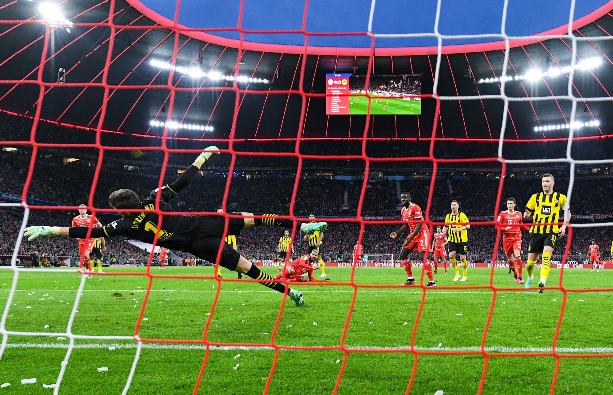 Eric Maxim Choupo-Moting (M) von München schießt auf das Tor von Torwart Gregor Kobel von Dortmund.