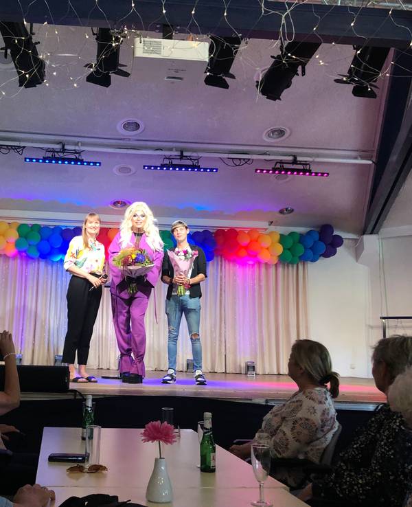 Die Kölner Dragqueen Pam Pengco (m.) gemeinsam mit Einrichtungsleiterin Susanne Bokelmann (l.) und Mitarbeiter Alexander Gatzen (r.) auf der Bühne.