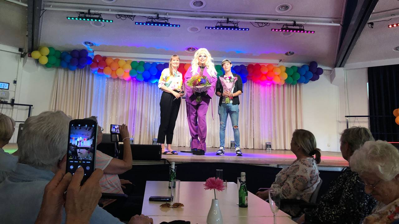 Die Kölner Dragqueen Pam Pengco (m.) gemeinsam mit Einrichtungsleiterin Susanne Bokelmann (l.) und Mitarbeiter Alexander Gatzen (r.) auf der Bühne.