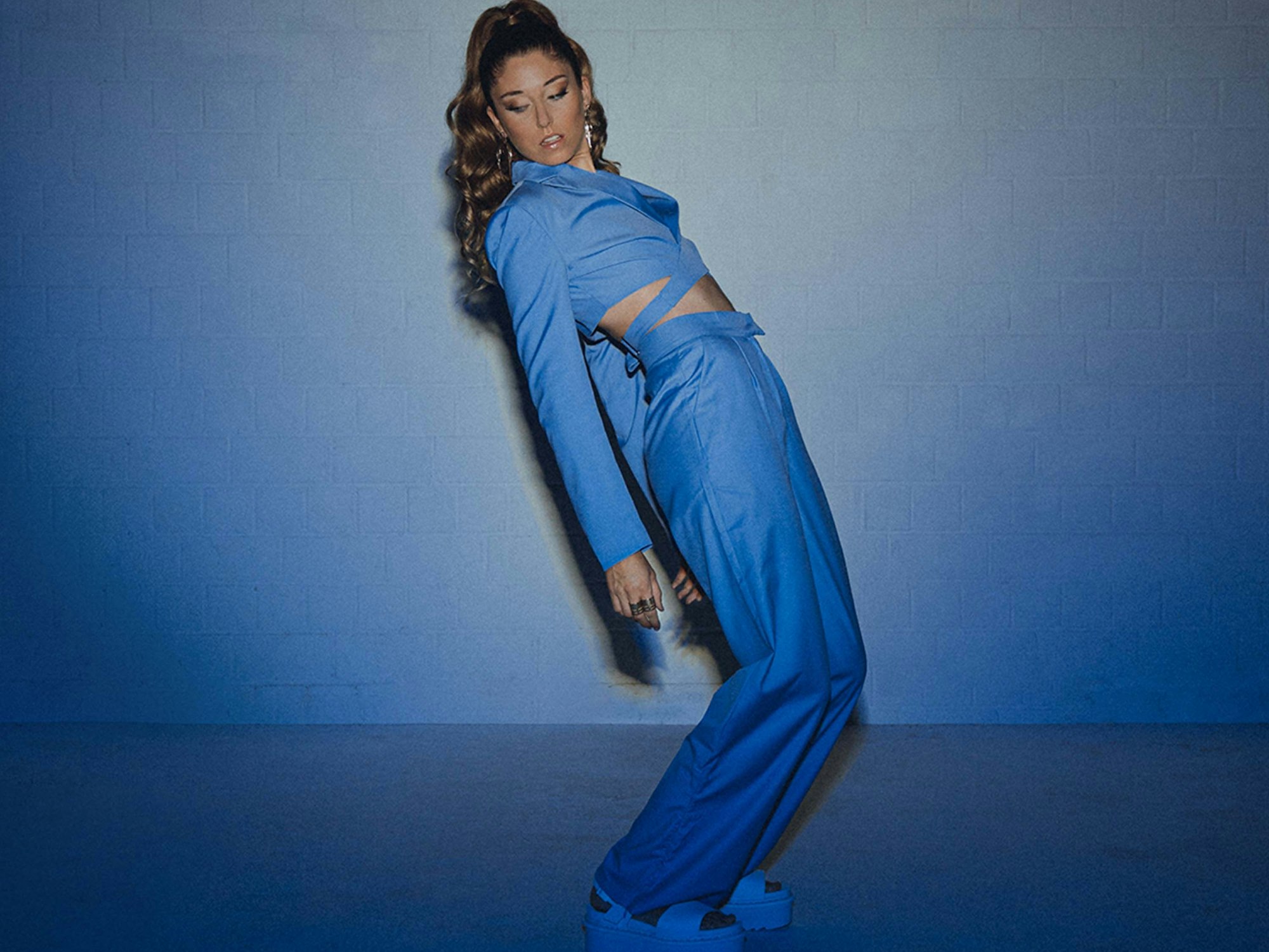 Die Sängerin Anna Grillmeier steht in blauem Licht.