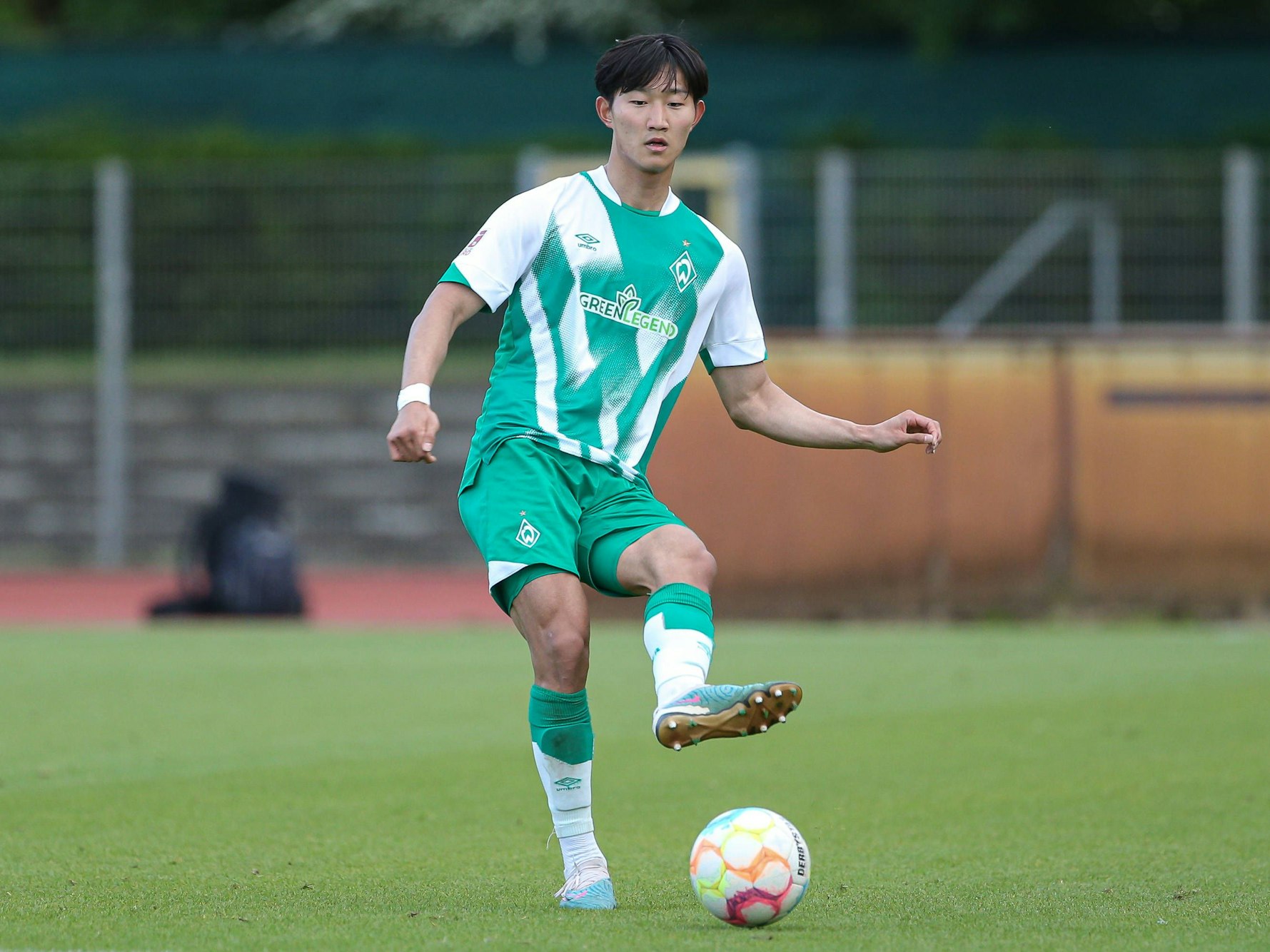 Min-woo Kim führt den Ball im Spiel gegen Holstein Kiel.
