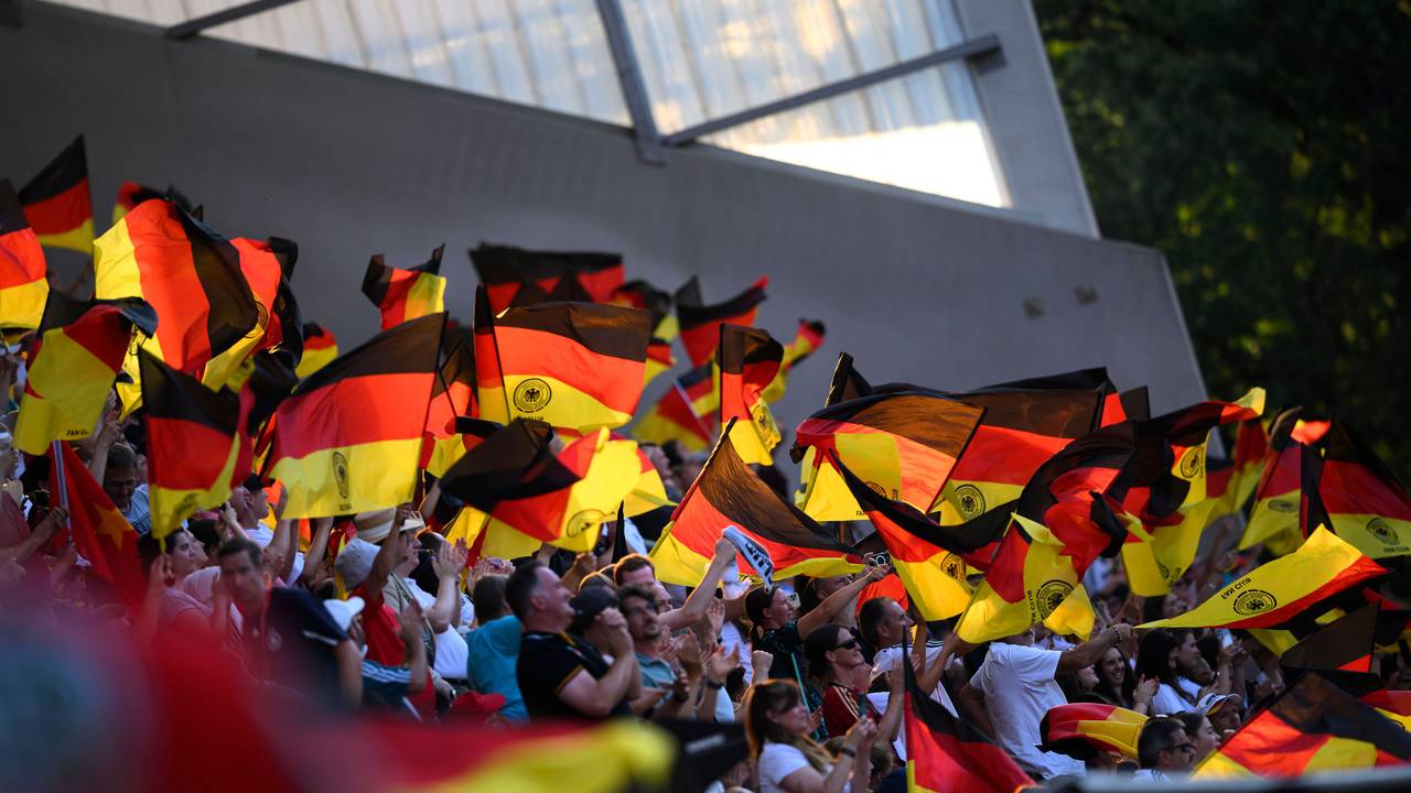 Deutschland-Fans schwingen Fahnen auf der Tribüne.