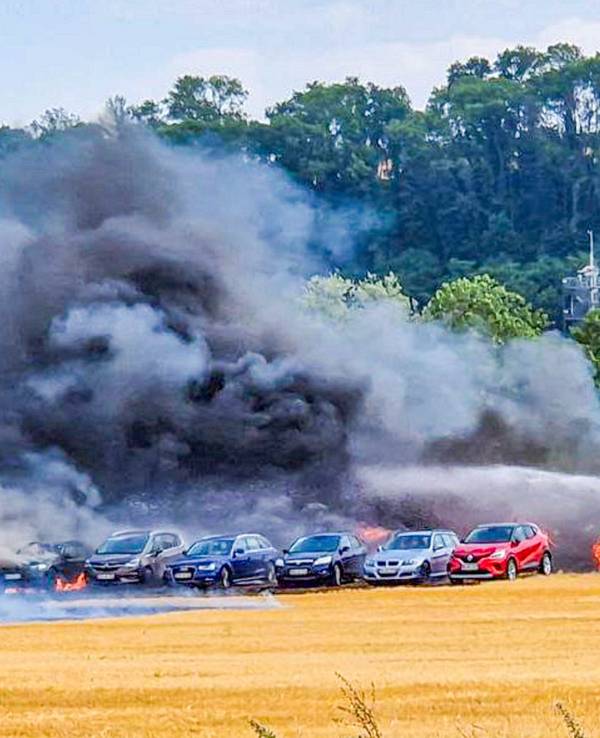 Autos stehen auf einem Parkplatz und werden von Rauchschwaden fast verhüllt. Mehrere Autos hatten Feuer gefangen.