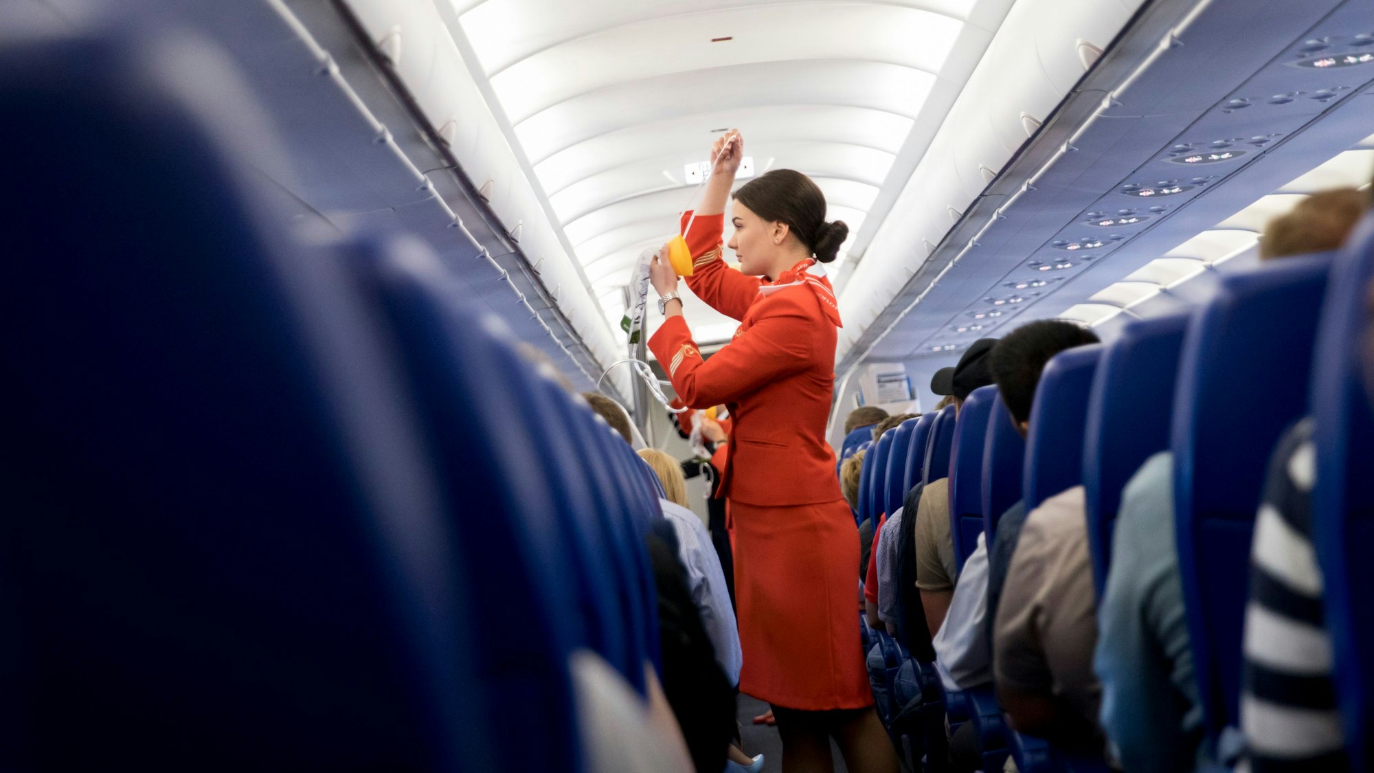 Eine Flugbegleiterin der russischen Fluglinie Aeroflot gibt in der Kabine eines Airbus A320 vor dem Start vom Flughafen in Moskau (Russland) Sicherheitseinweisungen an die Fluggäste.