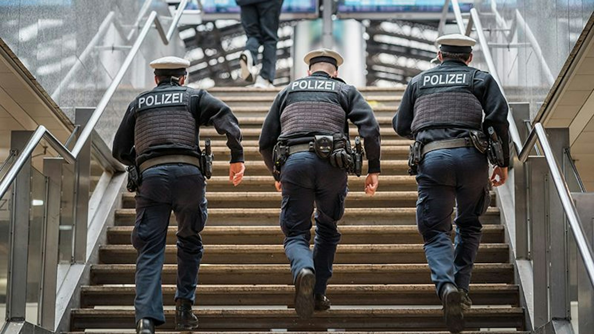 Bundespolizisten laufen am Kölner Hauptbahnhof eine Treppe hoch.