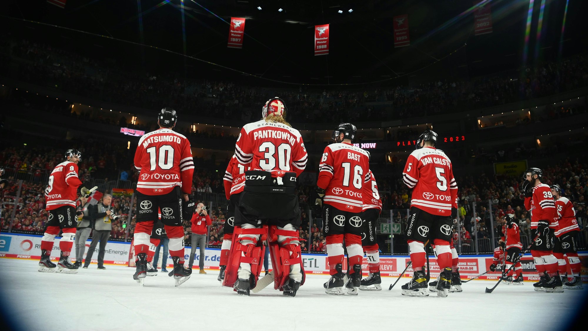 Die Spieler der Kölner Haie stehen bei einem DEL-Spiel in der Lanxess-Arena auf dem Eis.