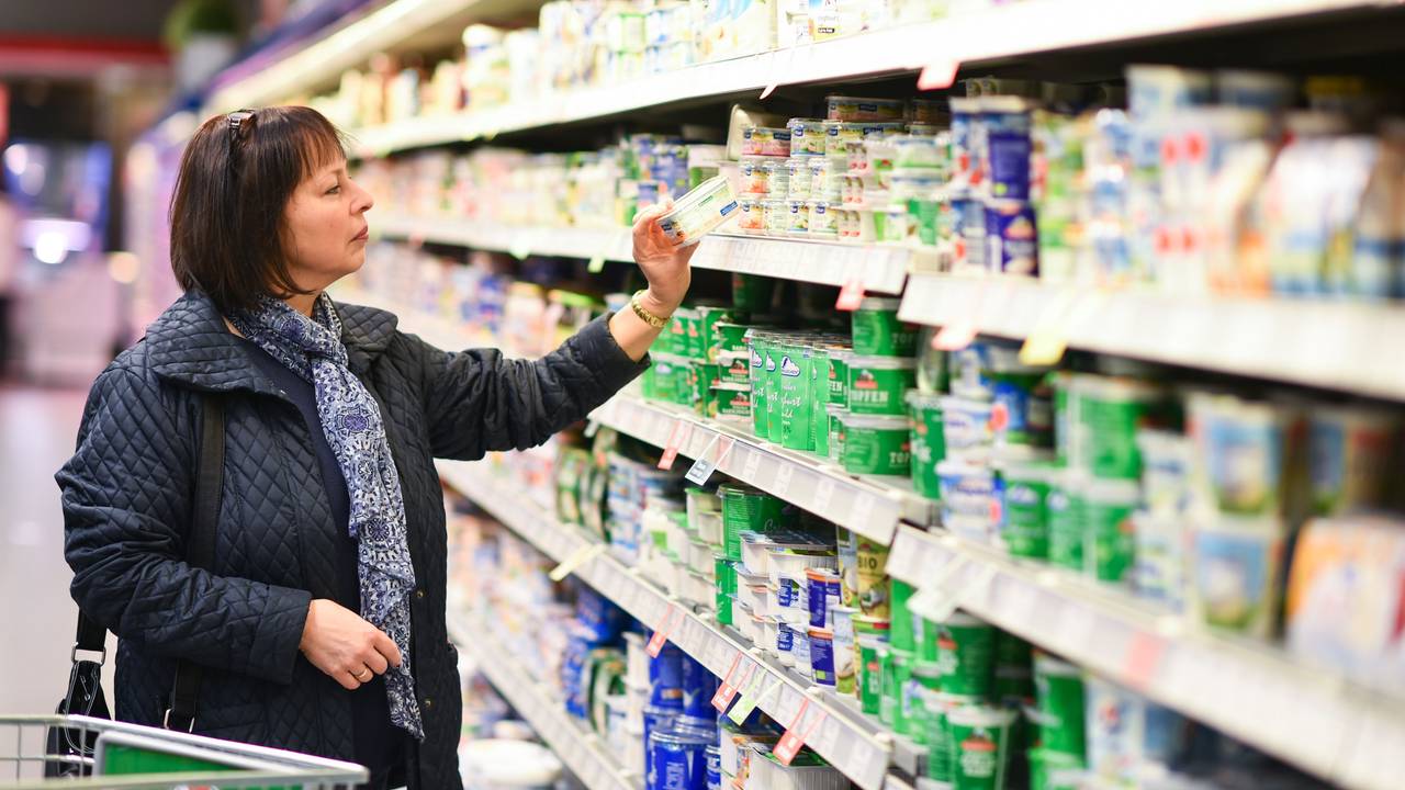 Eine Kundin steht in einem Edeka-Supermarkt an einem Kühlregal.