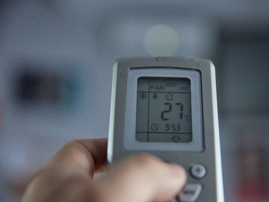 Fernbedienung einer Klimaanlage, auf dessen Display 27 Grad angezeigt werden.