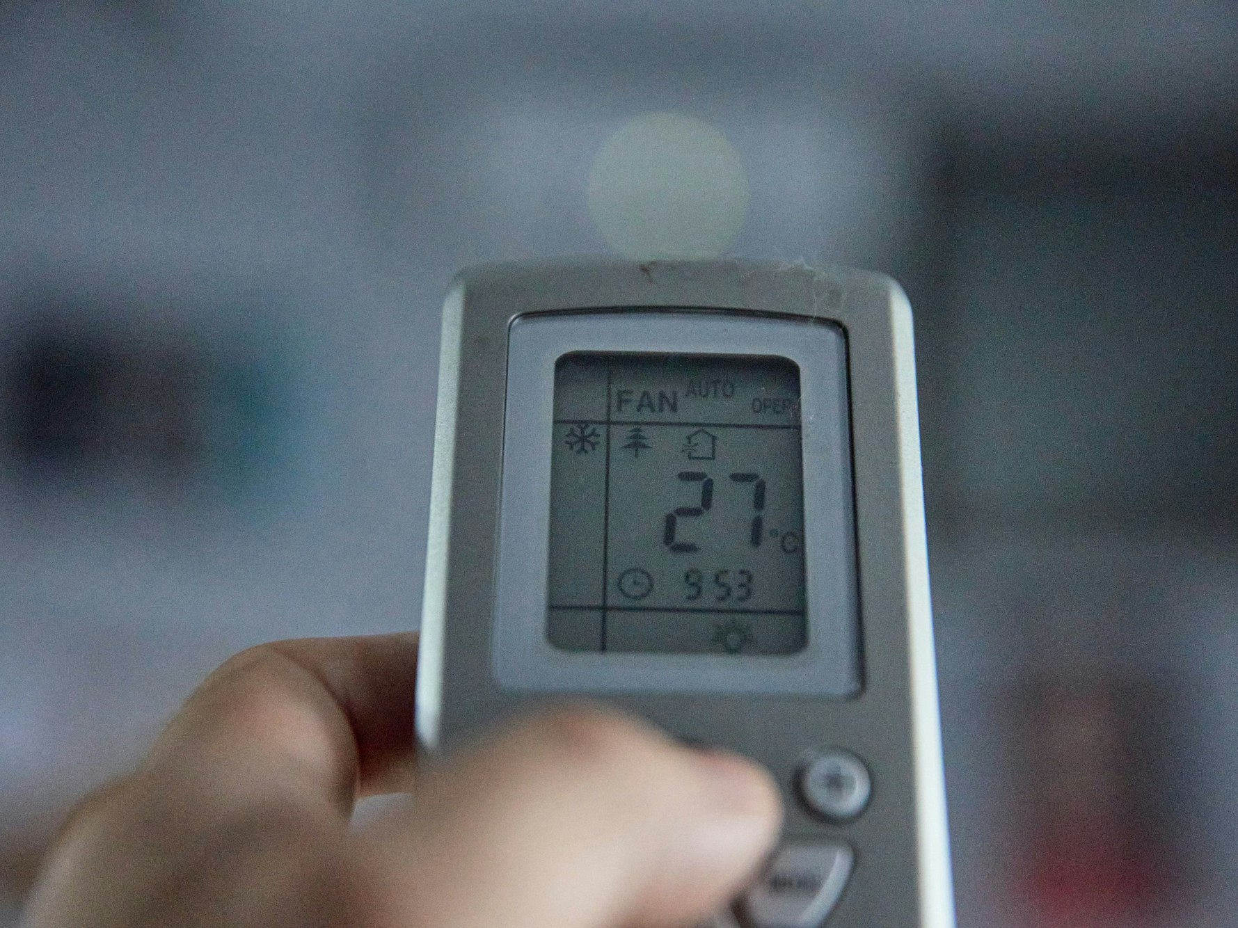 Fernbedienung einer Klimaanlage, auf dessen Display 27 Grad angezeigt werden.