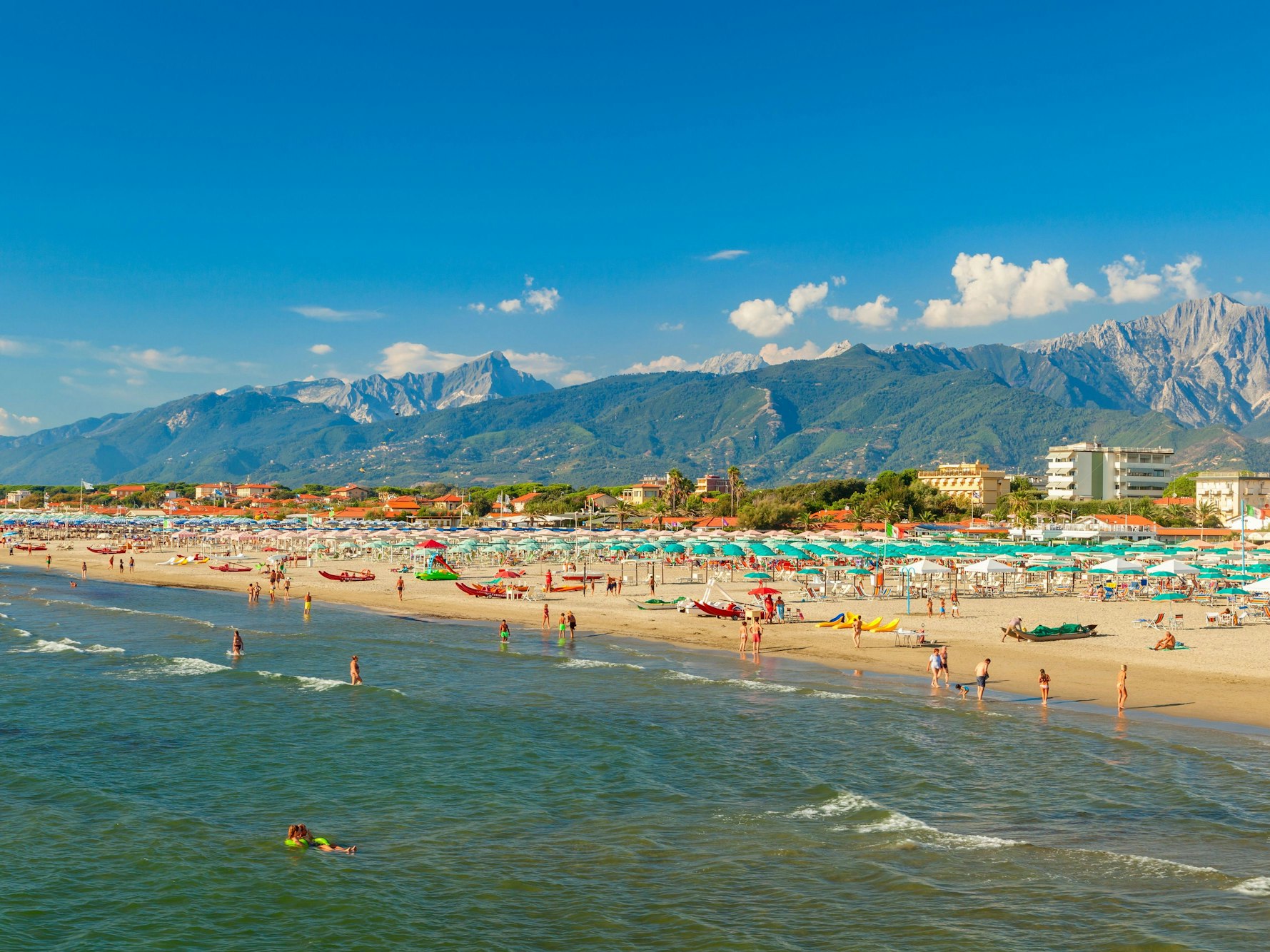 Sonniger Strandblick in Marina di Pietrasanta in Italien in der Toskana mit vielen ruhenden Menschen.